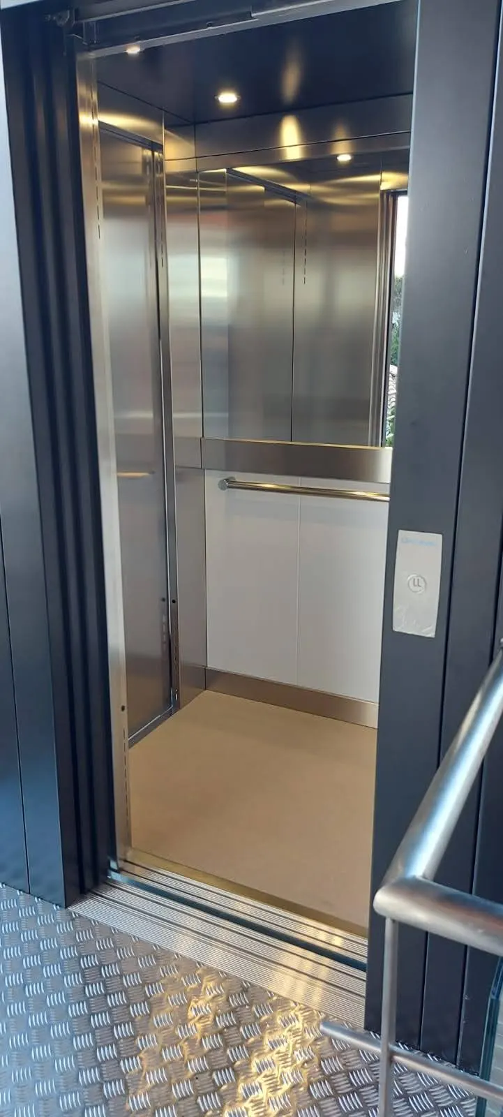 Stainless steel OnLevel EV8 cabin interior with handrail and open door