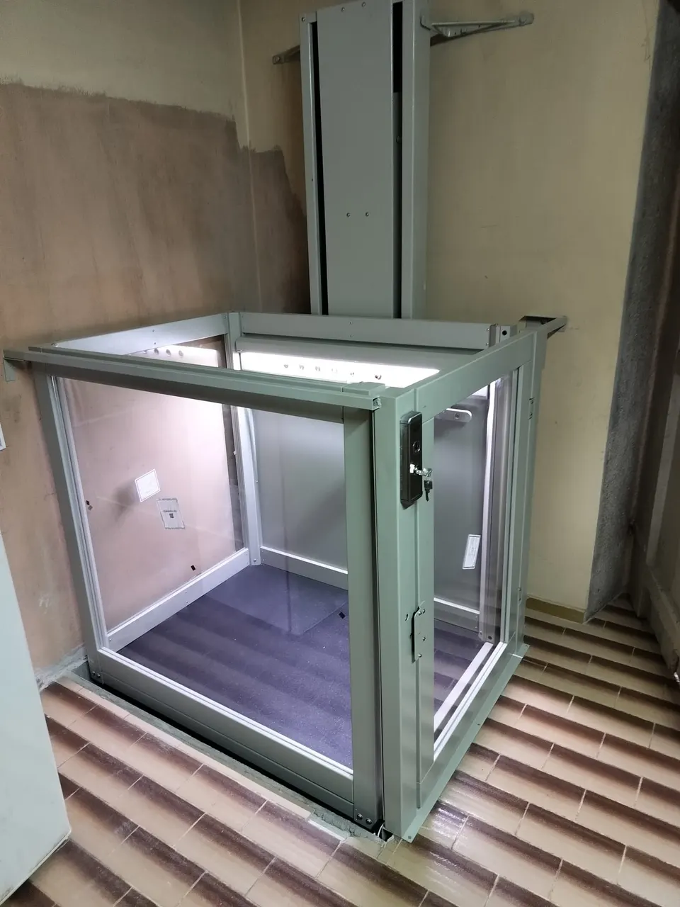 Glass-sided OnLevel PV30 platform lift at an upper tiled landing