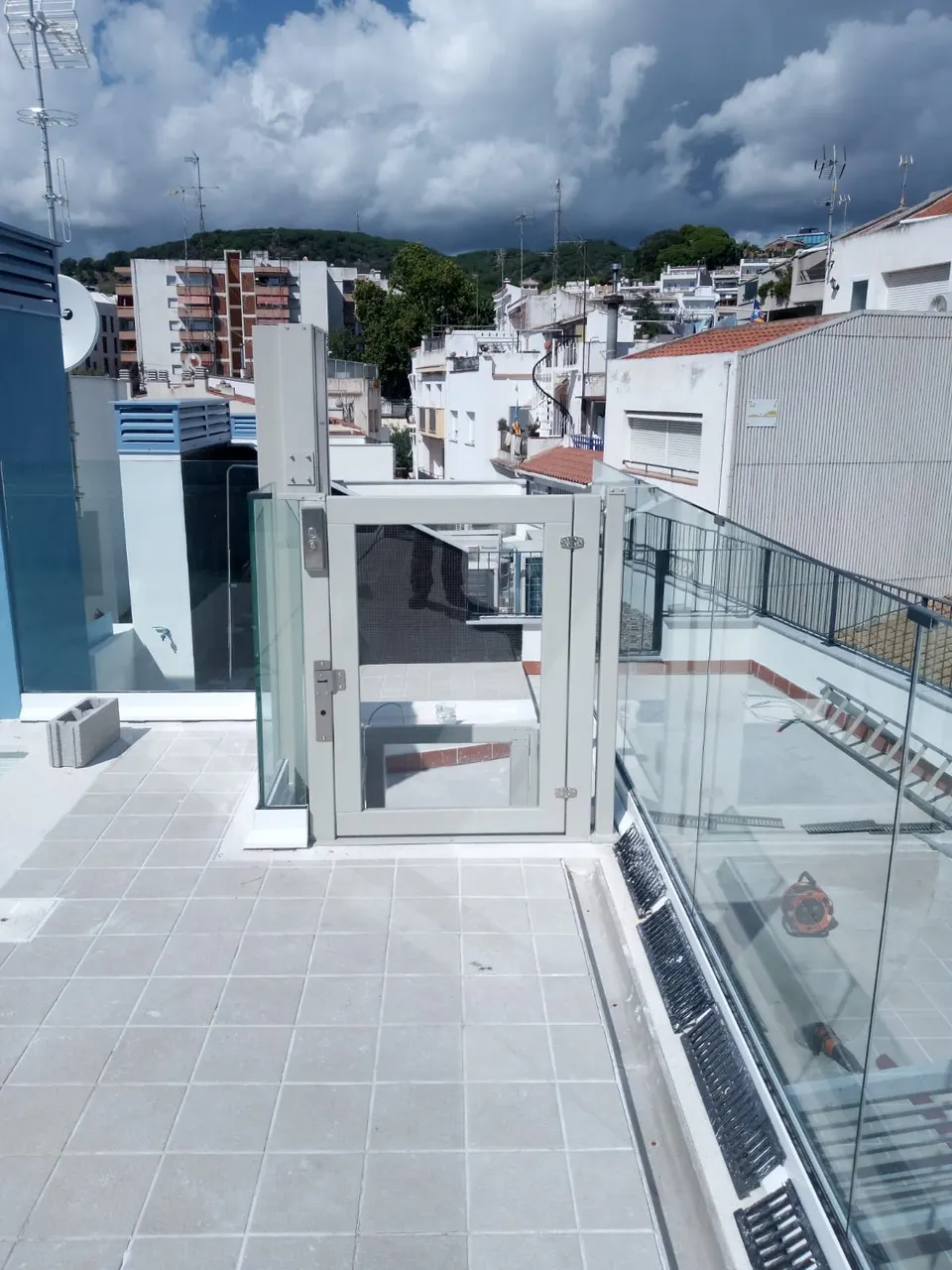 OnLevel PV30 platform lift on a rooftop terrace with townscape behind