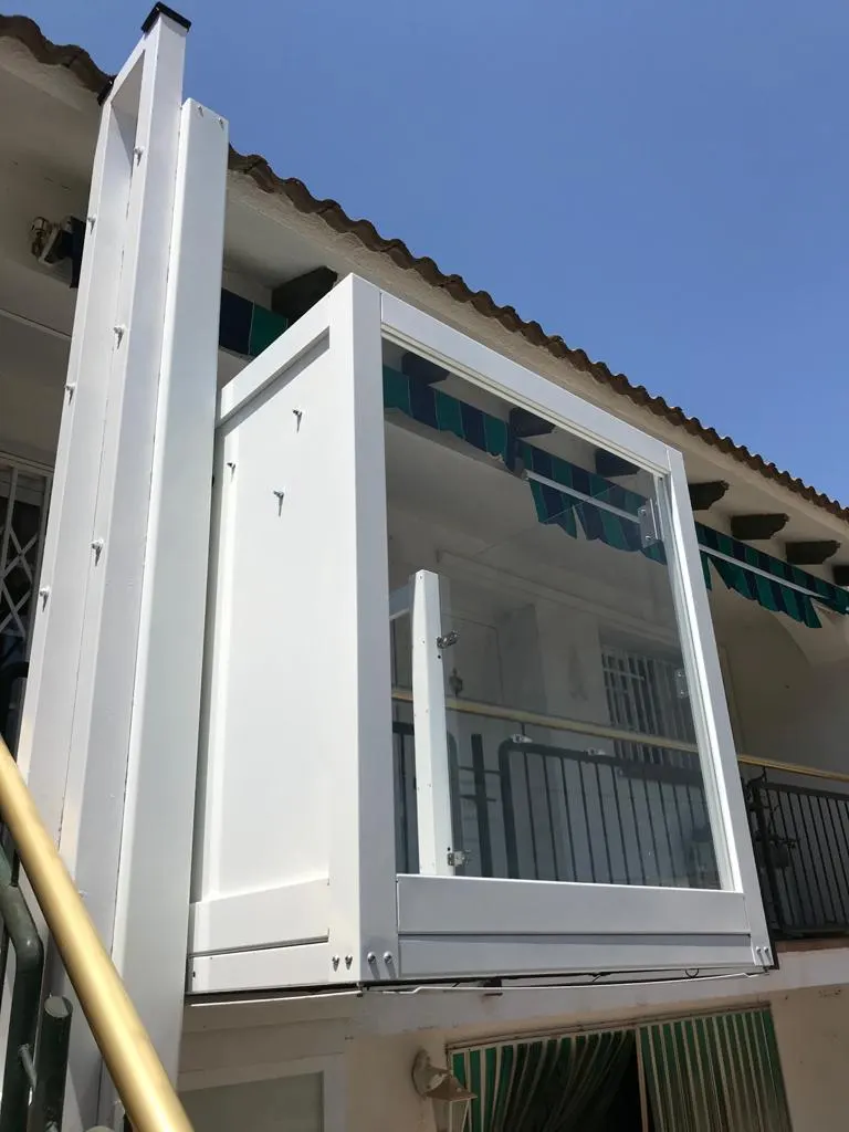White OnLevel PV30 platform lift against a terracotta roofline and blue sky