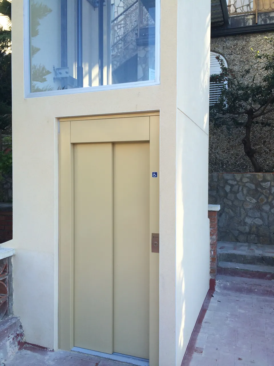 Beige external OnLevel home lift enclosure on a balcony with countryside behind