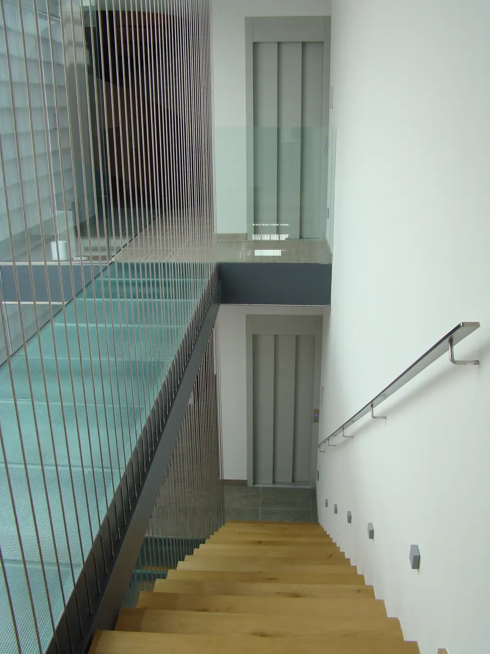OnLevel home lift landing doors on two floors of a modern oak staircase hallway